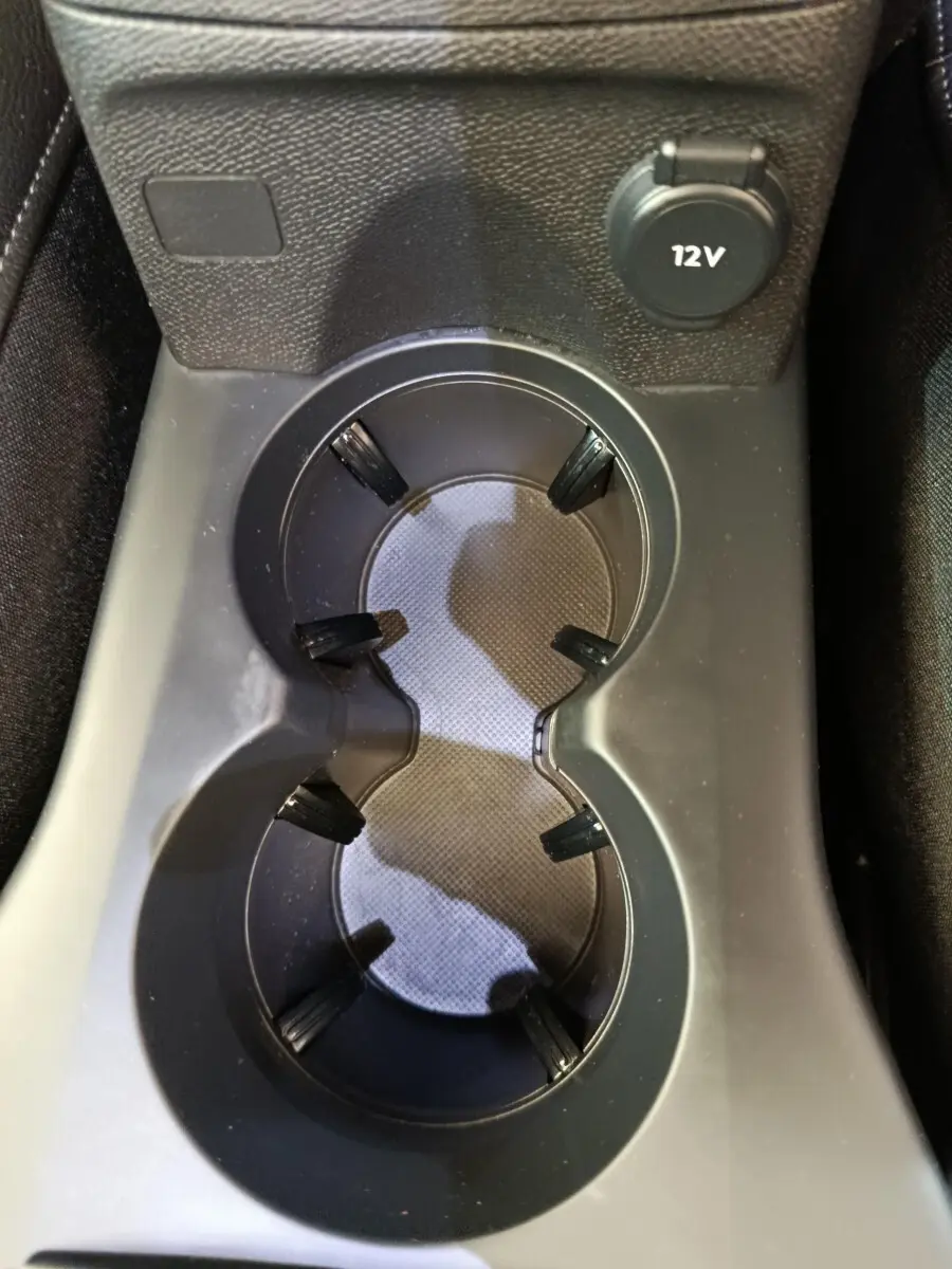 Gros plan sur les porte-gobelets et prise 12V dans l'habitacle gris foncé du DS3 1.2 PureTech 130 Auto 2024.