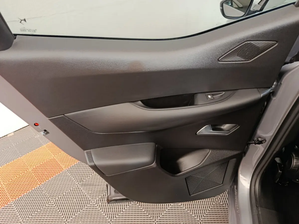 Vue rapprochée de la porte avant gauche gris foncé du DS3 2024, avec poignée et commande de vitre intégrées.