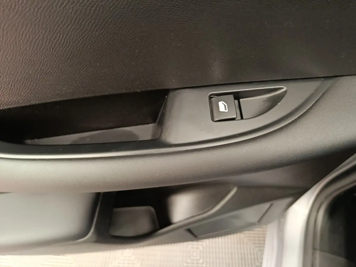 Gros plan sur la commande de verrouillage de porte côté conducteur de la DS3 1.2 PureTech 130 gris foncé, intérieur noir.