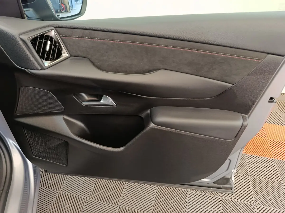 Vue rapprochée de la porte intérieure côté gauche gris foncé du DS3 2024 avec garniture en tissu et accoudoir intégré.