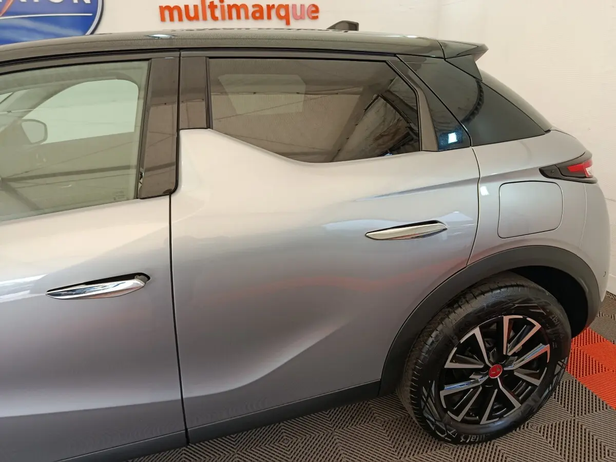 Vue latérale droite d'une DS3 gris foncé avec toit noir et jantes alliage distinctives.