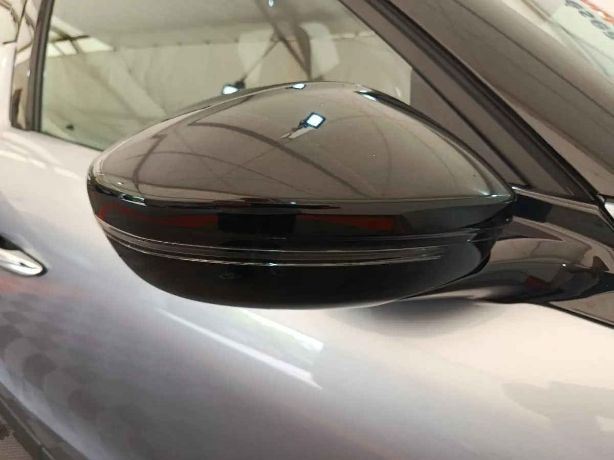 Gros plan sur le rétroviseur noir côté gauche d'une DS3 gris foncé 2024 avec clignotant intégré.