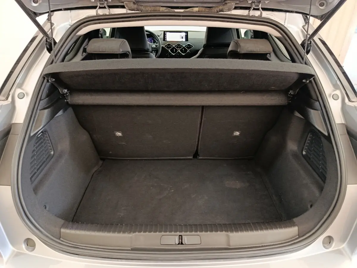 Coffre ouvert vu de l'arrière d'une DS3 gris foncé, montrant l'espace de chargement et l'intérieur noir.
