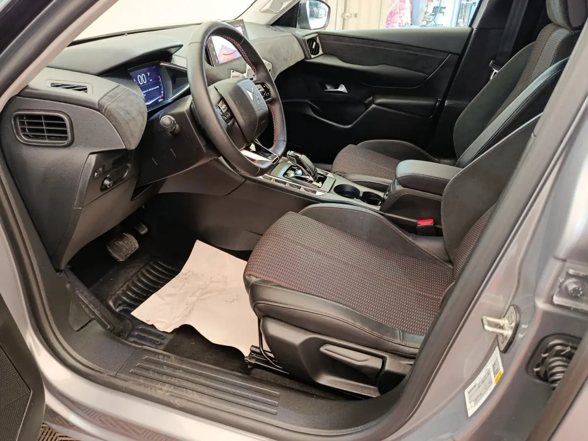 Vue intérieure côté conducteur de la DS3 2024 gris foncé, avec volant cuir multifonctions et écran digital tactile.