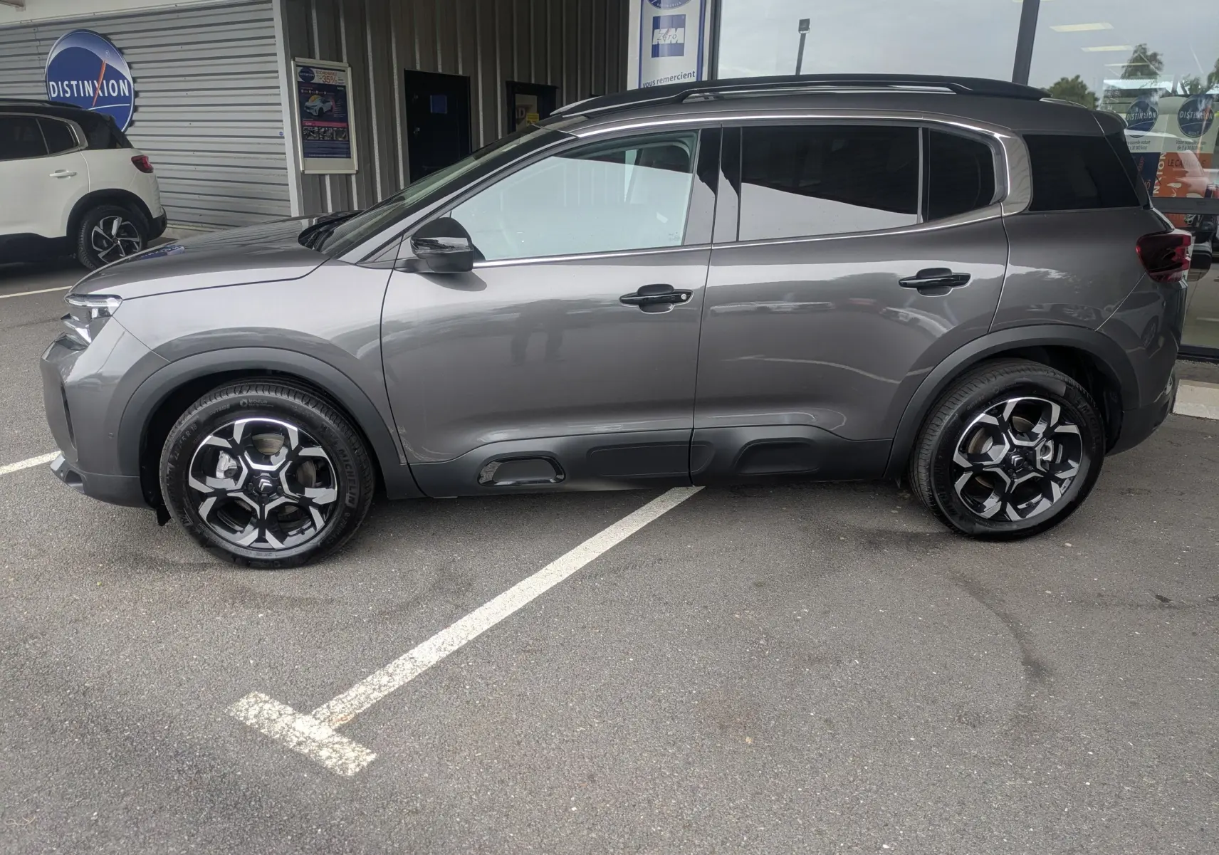 Profil côté gauche du Citroën C5 Aircross hybride gris platinium avec jantes alliage biton 18 pouces, vitres arrière surteintées.