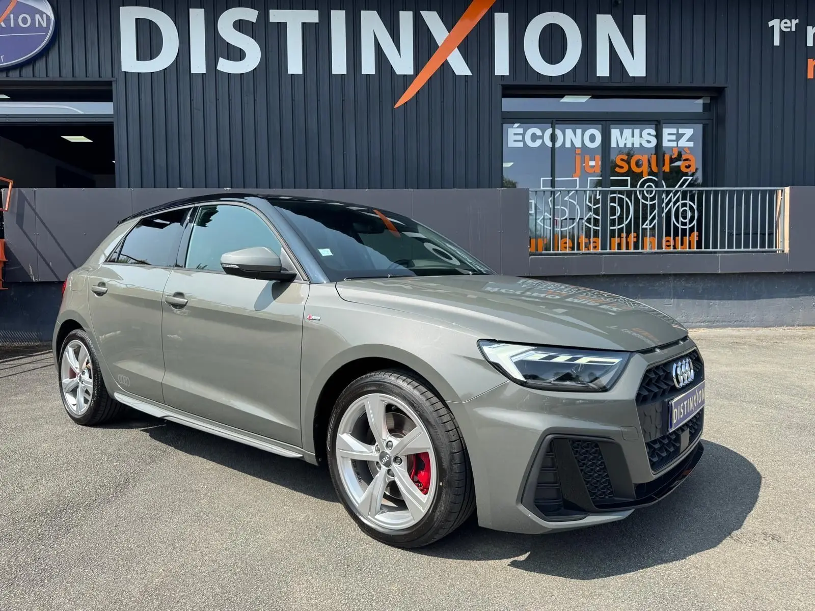 Audi A1 Sportback gris vue 3/4 avant droit, jantes alliage et étriers de frein rouges visibles.