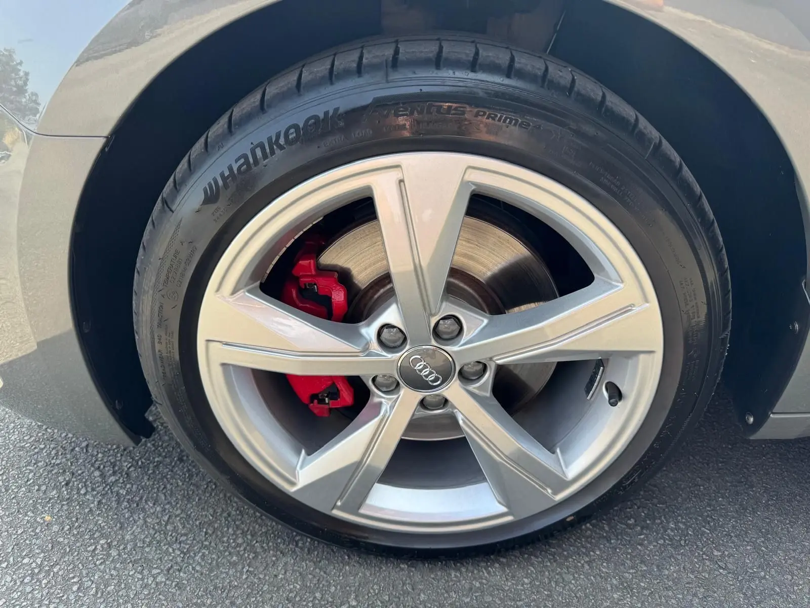 Gros plan sur la roue avant gauche grise d'une Audi A1 Sportback 2019 avec étrier de frein rouge et jante alu cinq branches.