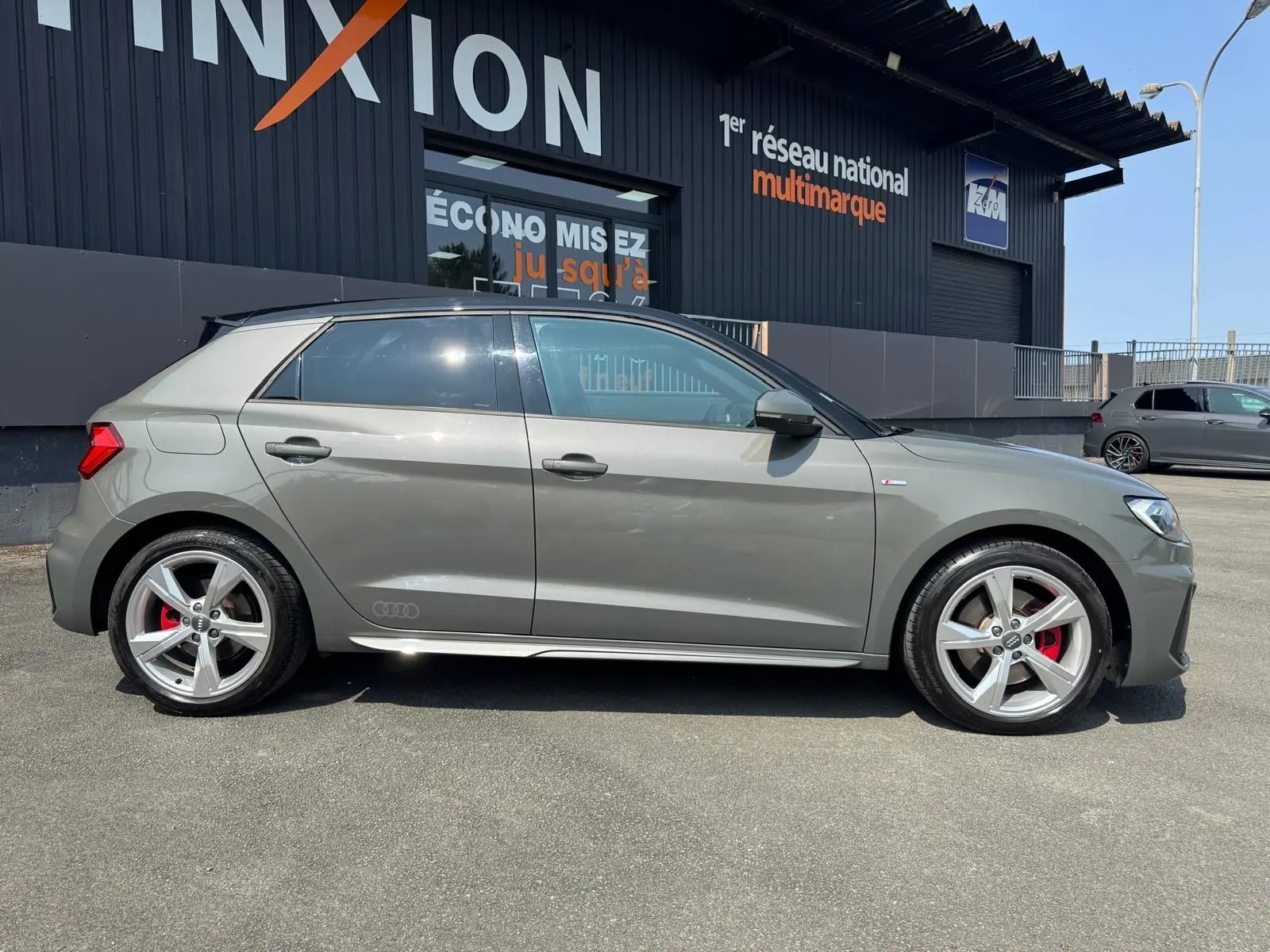 Audi A1 Sportback gris vue de profil côté gauche, avec jantes alliage et étriers de frein rouges visibles.