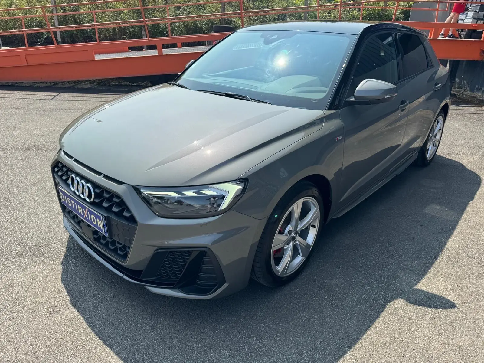 Audi A1 Sportback gris vue 3/4 avant droit, avec calandre hexagonale et jantes alliage cinq branches.