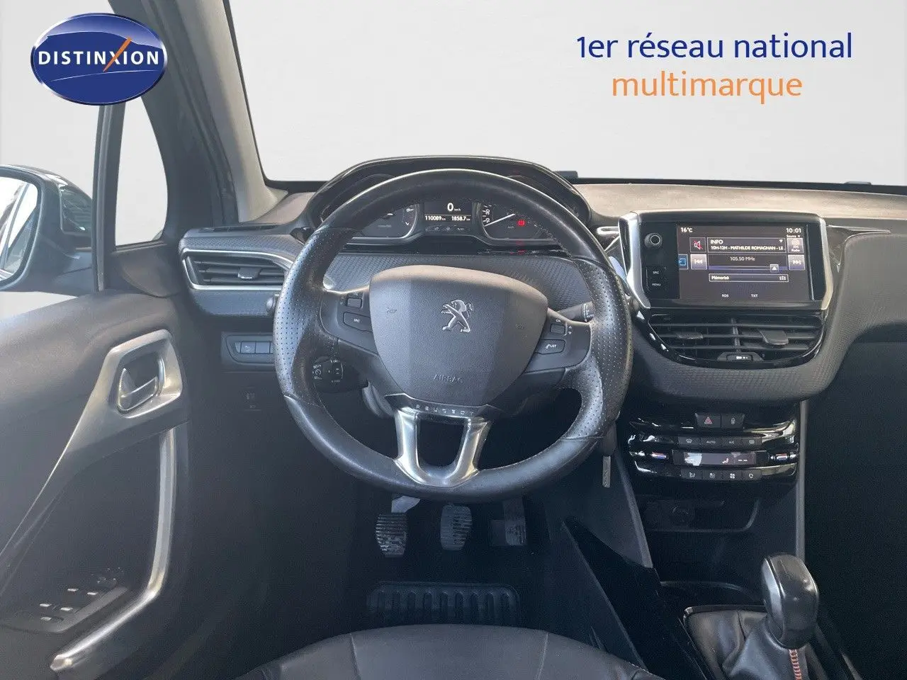 Vue intérieure centrée sur le volant et tableau de bord du Peugeot 2008 gris platinium, avec écran tactile et commandes au volant.