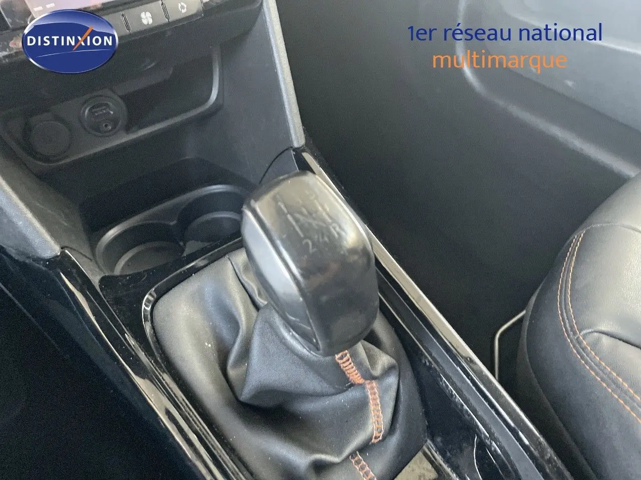 Gros plan sur le levier de vitesse manuel noir avec coutures marron à l'intérieur d'une Peugeot 2008 gris platinium.