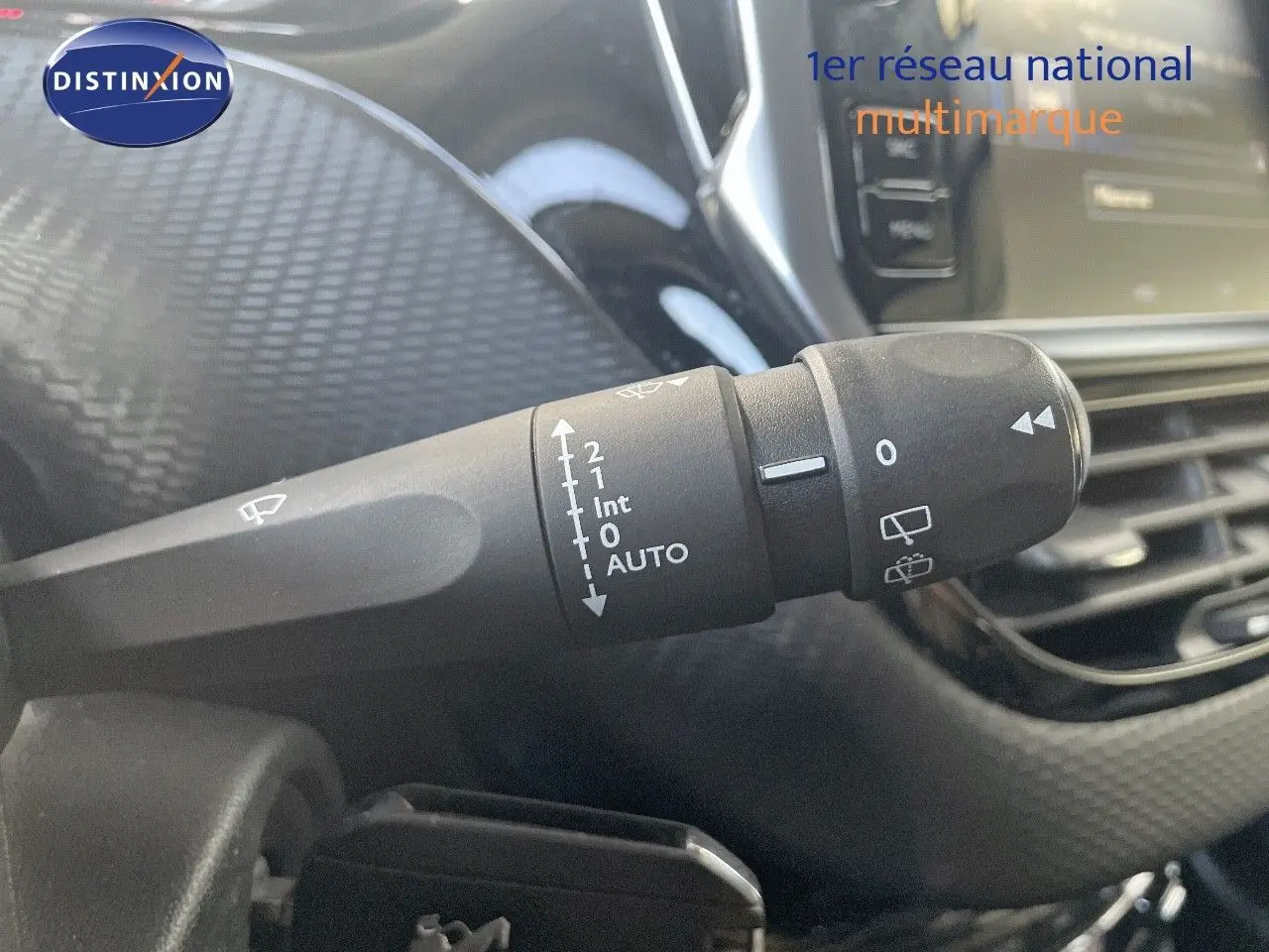 Gros plan sur la commande d’essuie-glace à gauche du volant dans l’habitacle d’un Peugeot 2008 gris platinium.