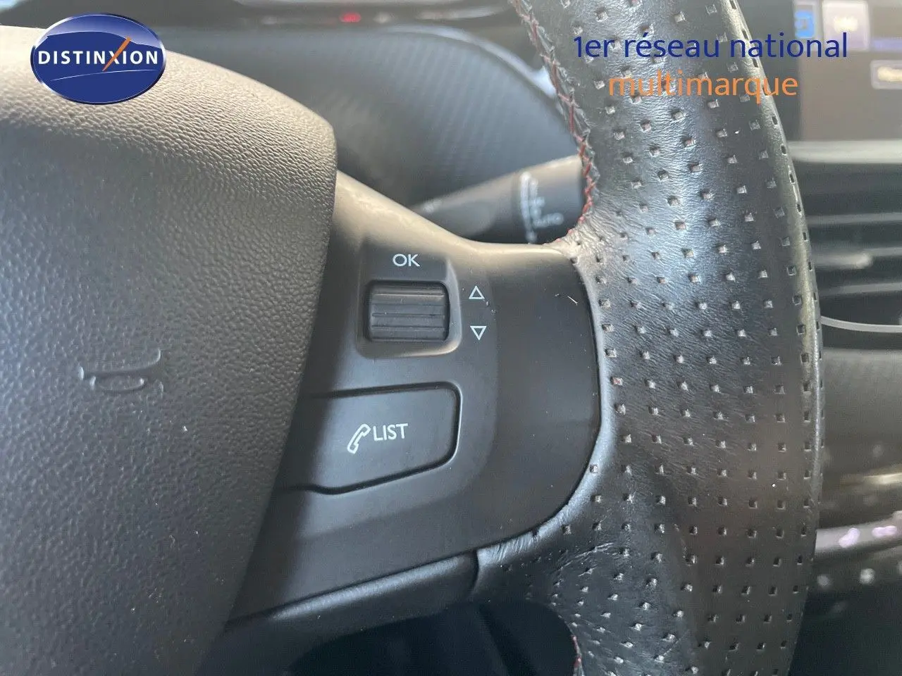Gros plan sur le volant en cuir perforé avec commandes intégrées du Peugeot 2008 gris platinium, version 2019.