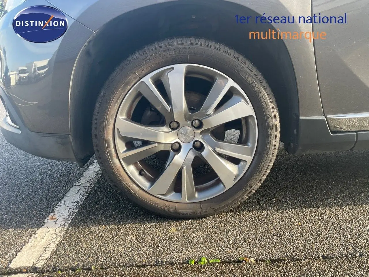 Gros plan sur la roue avant gauche d’un Peugeot 2008 gris platinium métal, mettant en valeur la jante alliage 17 pouces.