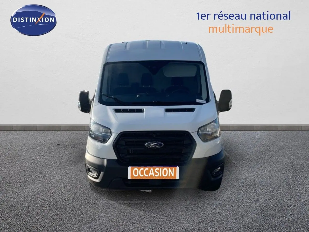 Vue frontale d'un fourgon Ford Transit blanc 2023 avec calandre noire et plaque "OCCASION" visible.