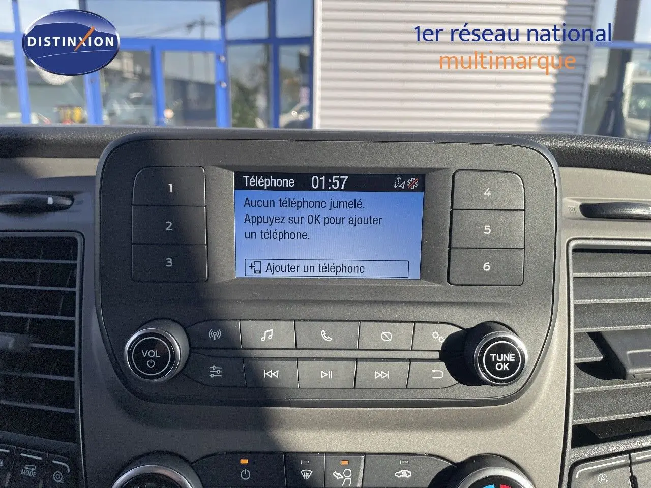 Vue rapprochée du tableau de bord noir du Ford Transit Fourgon blanc, avec écran central affichant le menu téléphone.
