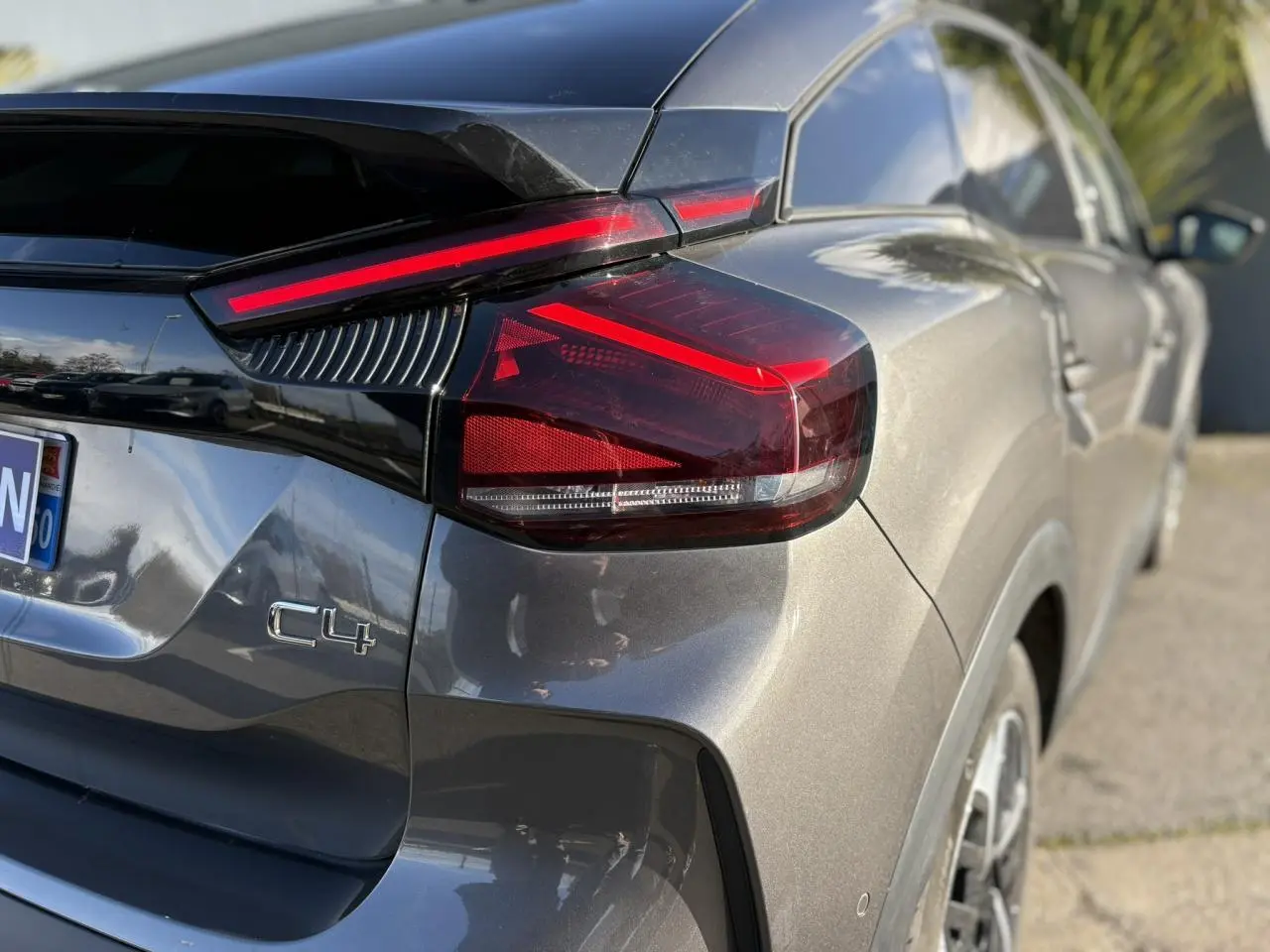 Vue 3/4 arrière droite d'une Citroën C4 gris Platinium avec feux arrière LED et jantes alliage 18 pouces.