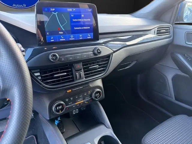 Vue intérieure côté passager de la Ford Focus 1.5 EcoBoost 150ch ST-Line BVA 2022 avec écran tactile et tableau de bord noir.