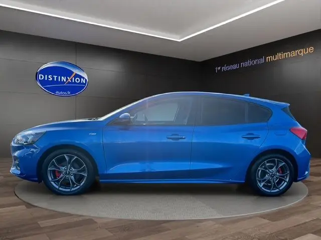 Vue de profil côté gauche d'une Ford Focus 1.5 EcoBoost 150ch ST-Line BVA bleu avec jantes alliage et étriers rouges.