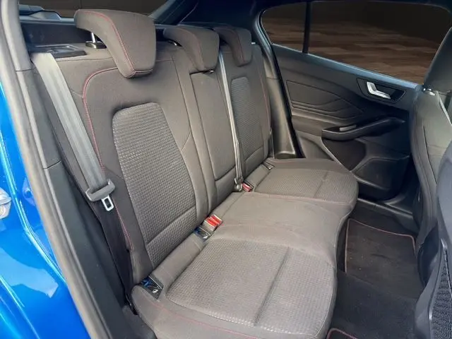 Vue intérieure côté droit des sièges arrière en tissu gris avec surpiqûres rouges d'une Ford Focus 1.5 EcoBoost 2022 bleue.