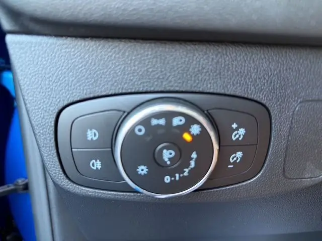 Gros plan sur la molette de réglage des phares du Ford Focus bleu 1.5 EcoBoost 150ch ST-Line BVA 2022.