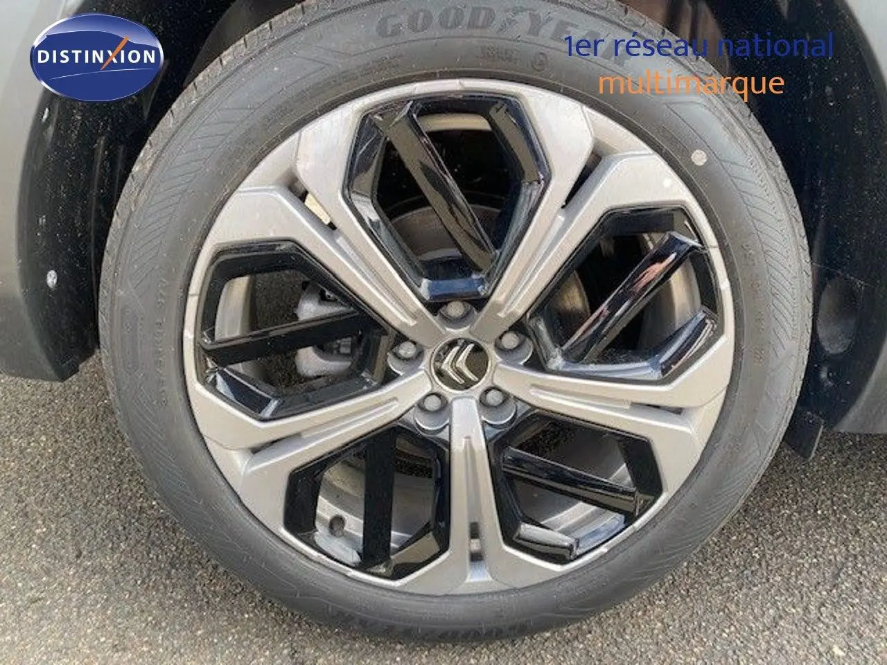 Gros plan sur la jante bi-ton gris et noir avec logo Citroën, roue avant droite d'une C5 X gris platinium.