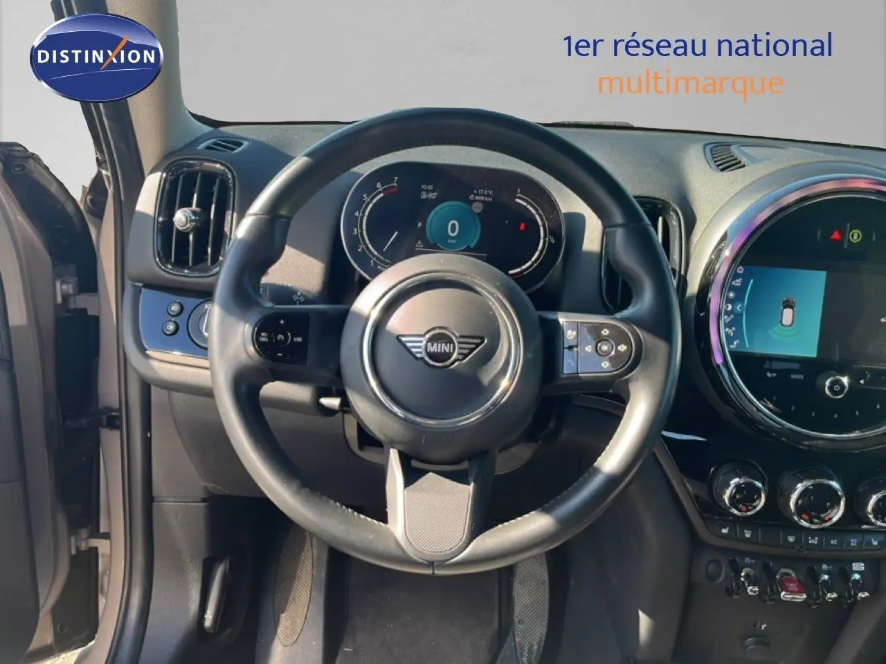 Vue intérieure centrée sur le volant du MINI Countryman 2023, tableau de bord numérique et écran tactile circulaire.