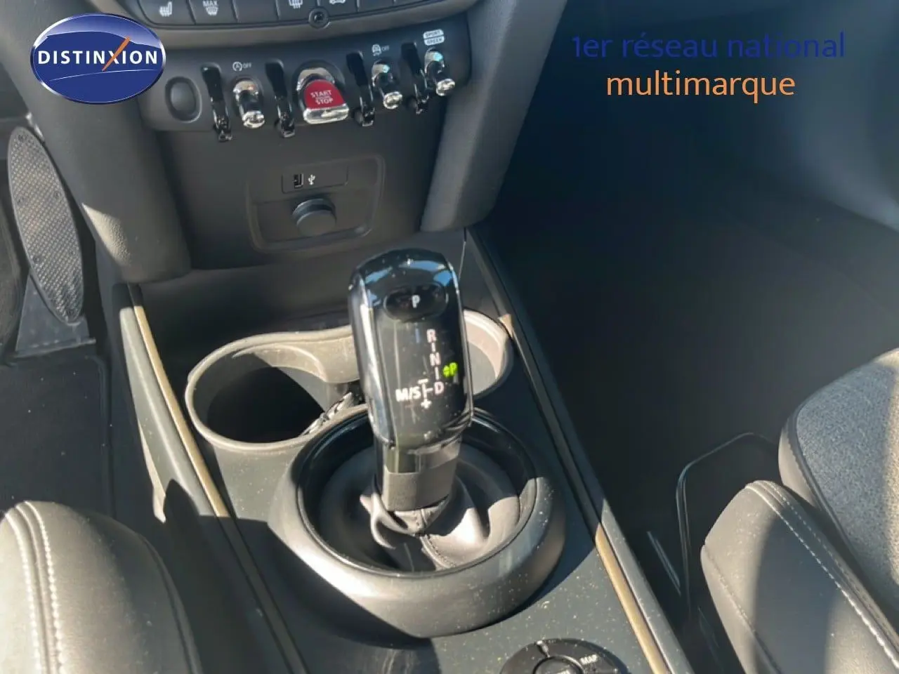 Gros plan sur la console centrale d’une MINI Countryman 2023, levier de boîte auto noir et détails des commandes.