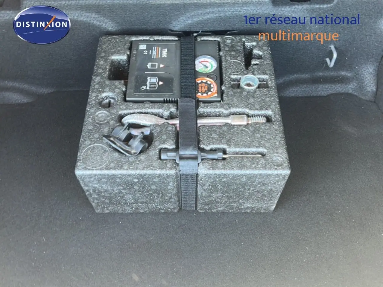 Vue du coffre d’une MINI Countryman Cooper 2023, montrant le kit de réparation rangé dans un compartiment en mousse grise.