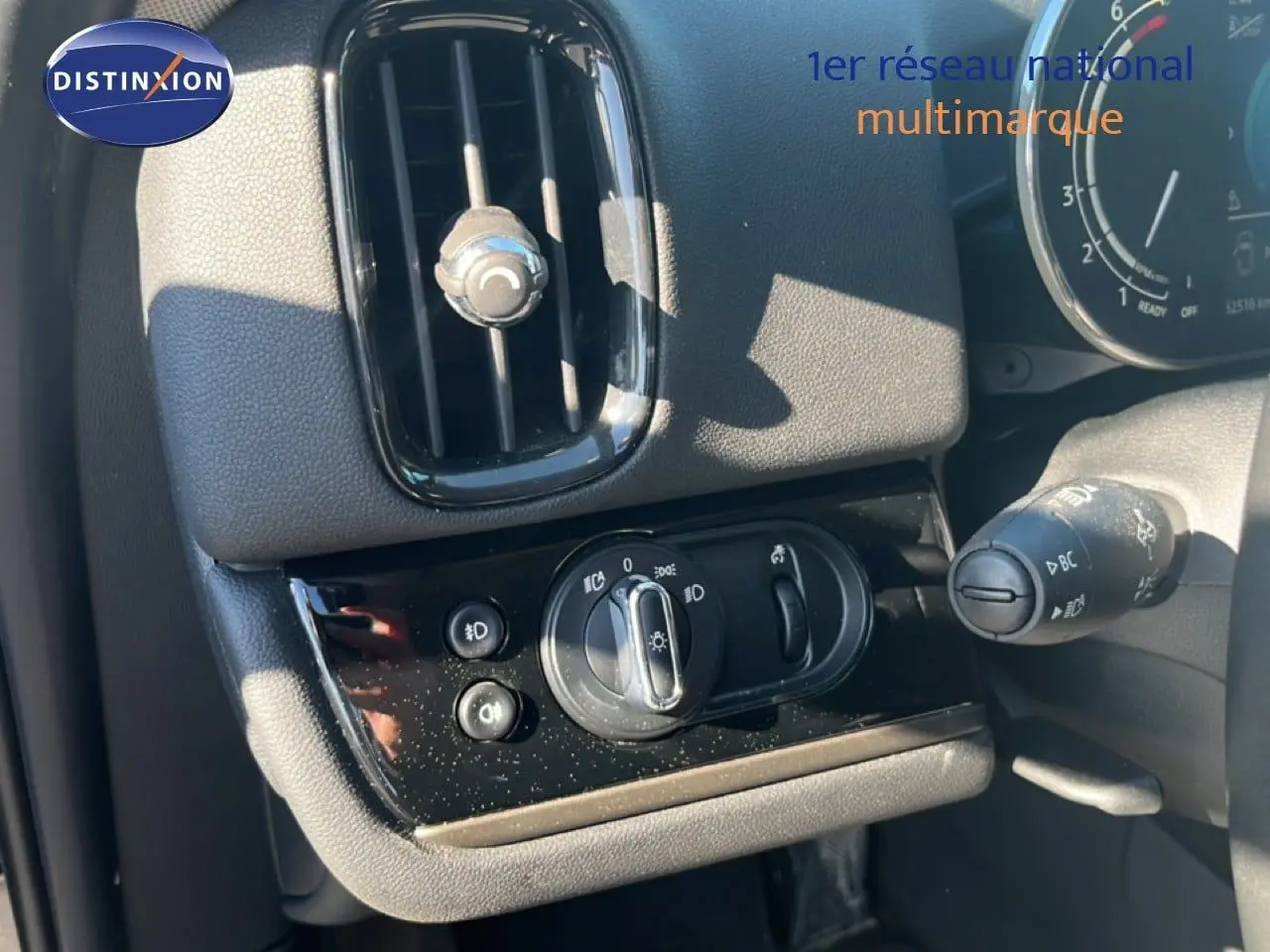 Détail du tableau de bord côté gauche du MINI Countryman Cooper 2023 avec commandes d’éclairage et aérateur noir.