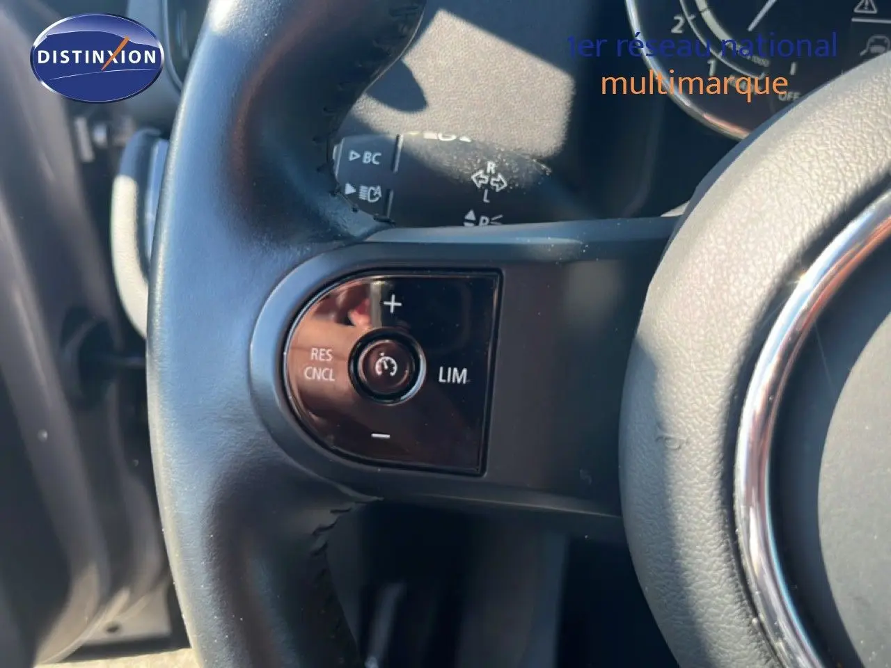 Gros plan sur les commandes de régulateur de vitesse au volant cuir noir d'une MINI Countryman 2023 Rooftop Grey.