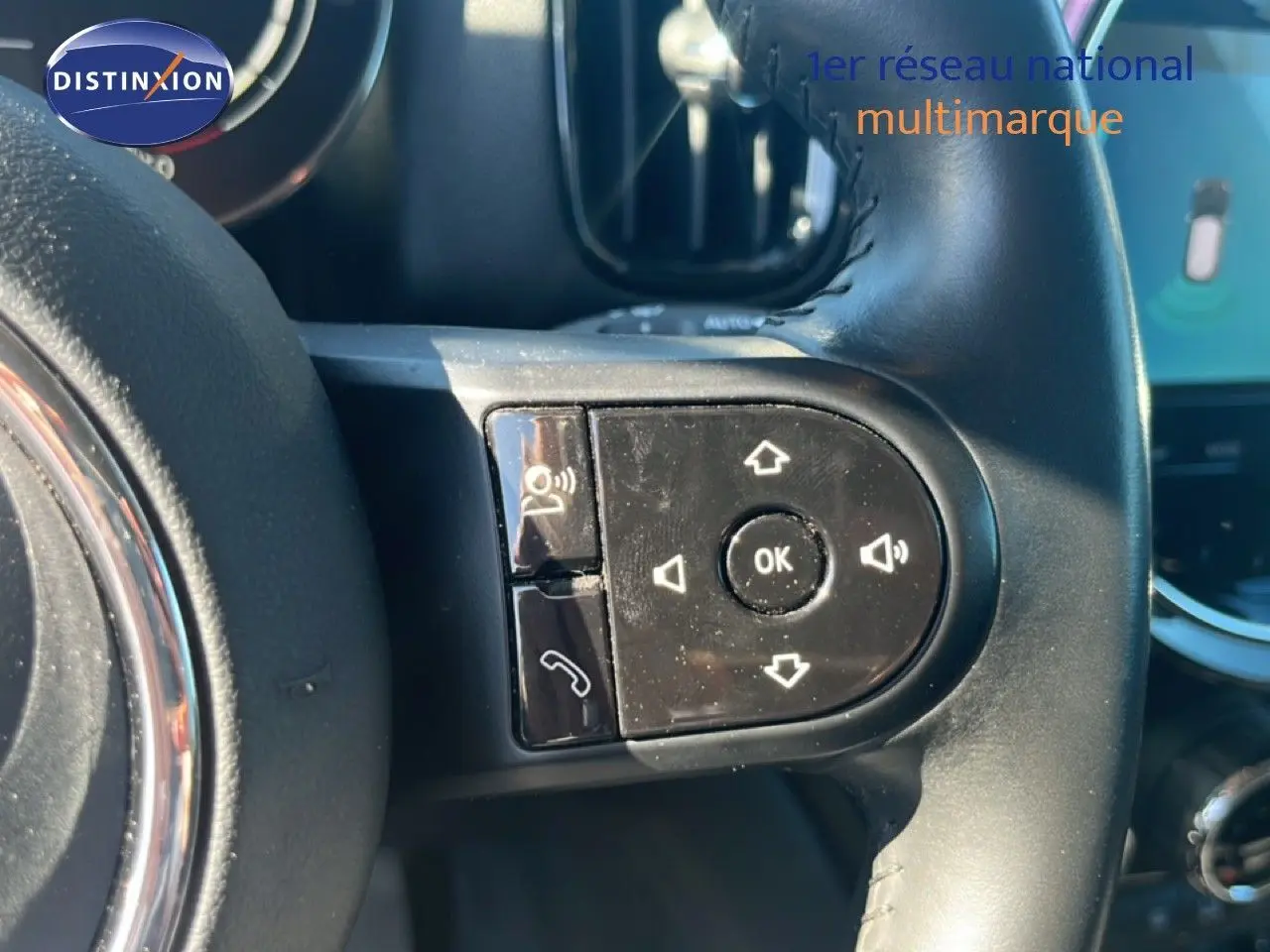 Gros plan sur les commandes au volant à droite du MINI Countryman 2023 en Rooftop Grey Metal, intérieur noir.