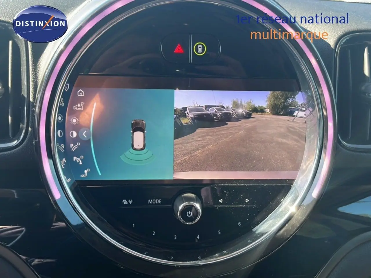 Écran central rond de la MINI Countryman Cooper 2023 montrant la caméra de recul et les capteurs de stationnement.