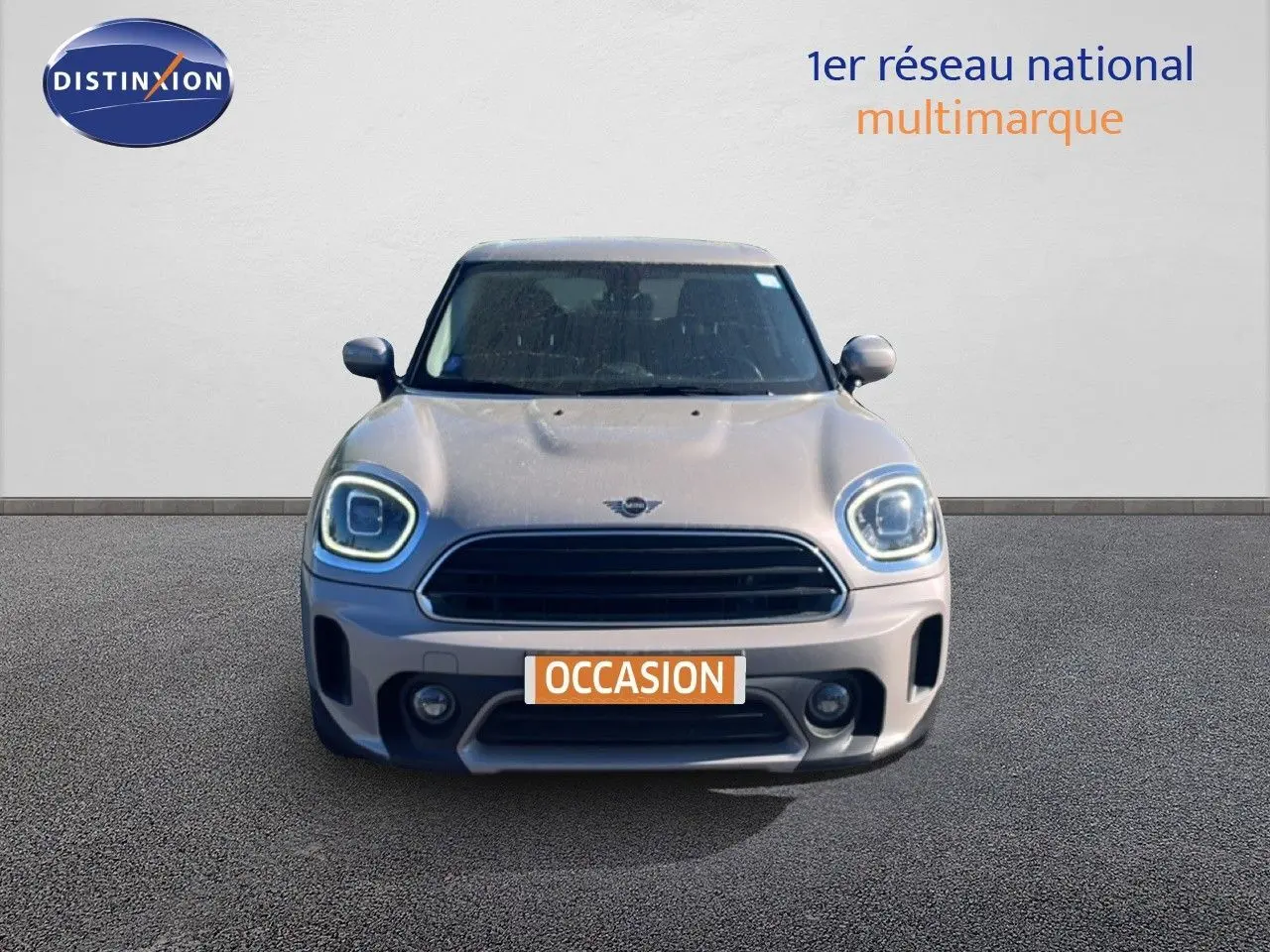 Vue frontale d'une MINI Countryman Cooper 2023 en gris rooftop avec phares LED allumés et plaque occasion.
