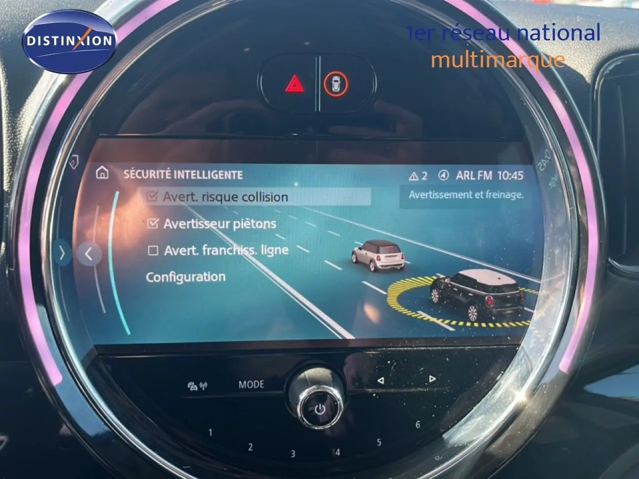 Écran central rond du MINI Countryman 2023 affichant les options de sécurité intelligente avec interface moderne et éclairage LED.