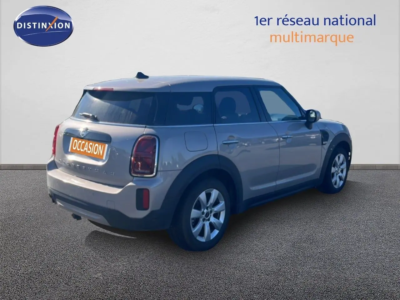Vue 3/4 arrière droite d'une MINI Countryman Cooper grise rooftop avec toit noir et jantes argentées.