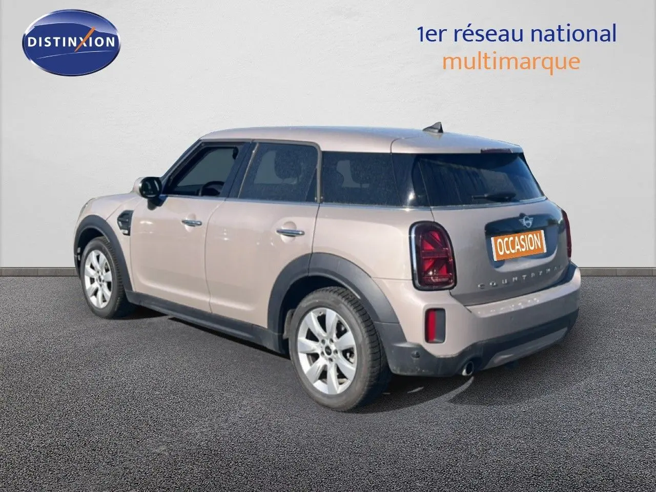 Vue 3/4 arrière droite d'une MINI Countryman Cooper 2023 en rooftop grey metal avec feux arrière foncés et jantes argentées.