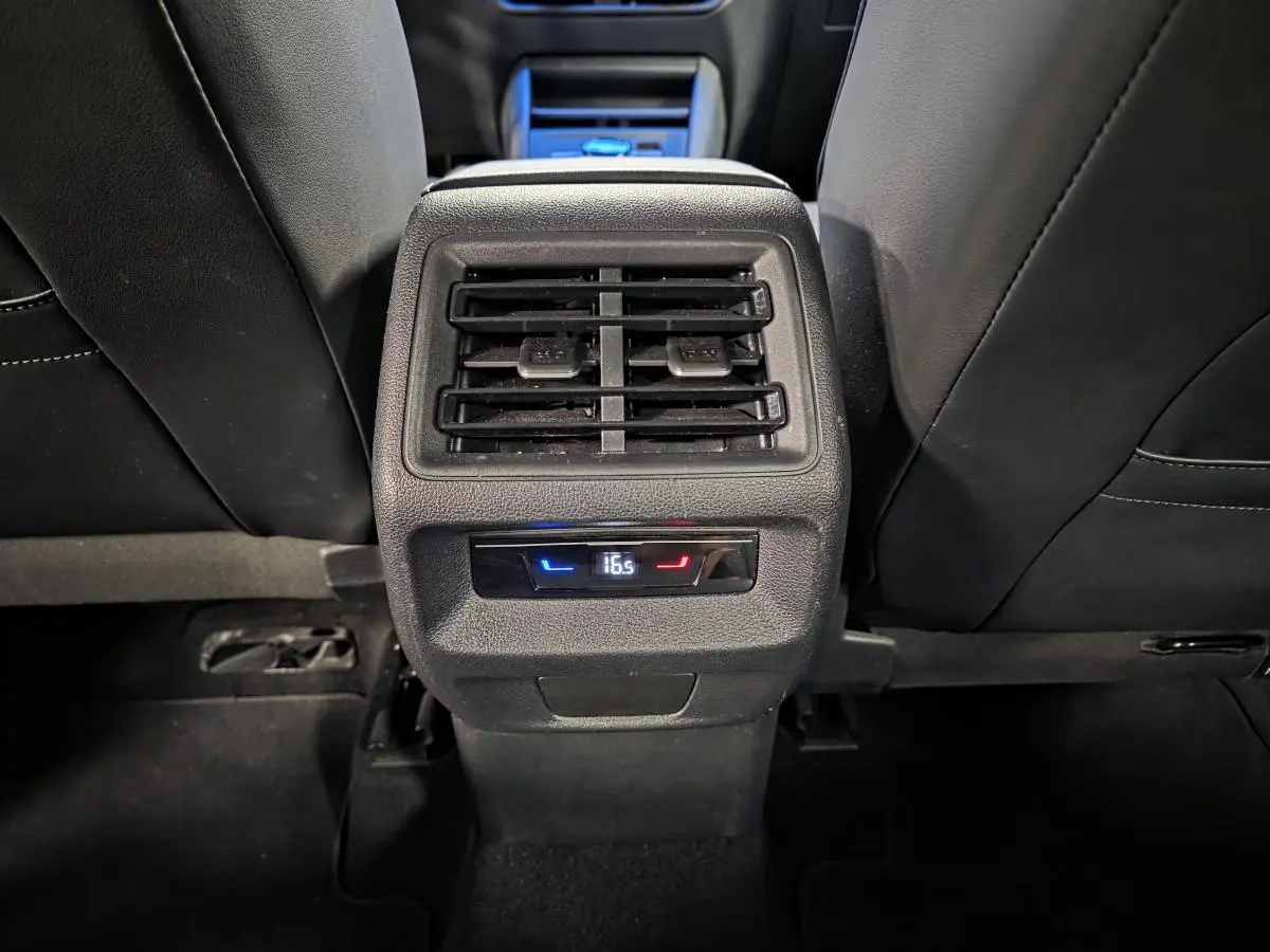 Vue rapprochée de la console centrale arrière noire du Volkswagen Tiguan 2025 avec ventilation et réglage climatique digital.