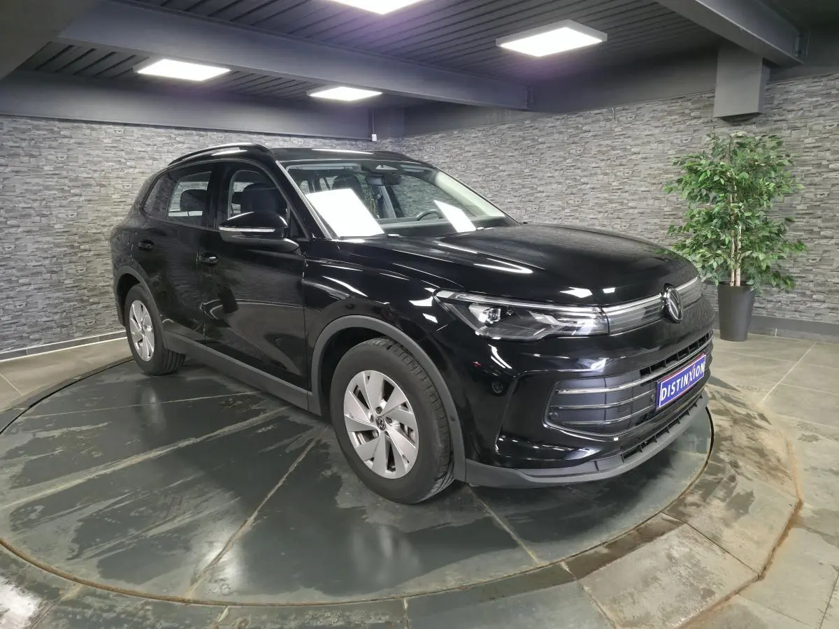 Volkswagen Tiguan 2025 noir métallisé en 3/4 avant gauche, avec jantes alliage 17 pouces et calandre distinctive.