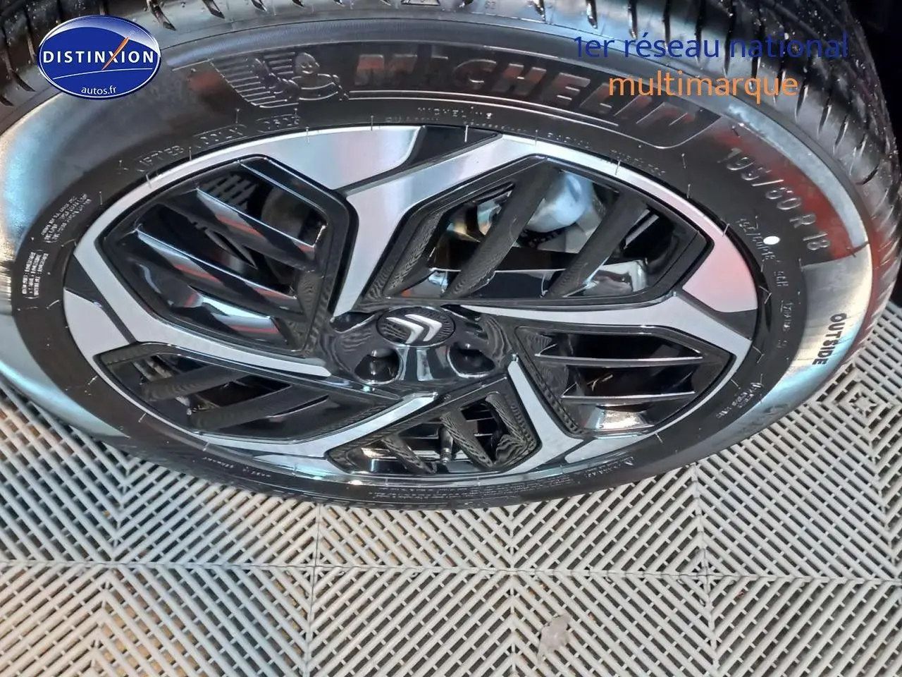 Gros plan sur la jante biton noire et gris platinium d'une Citroën C4 X 2023, pneus Michelin visibles.