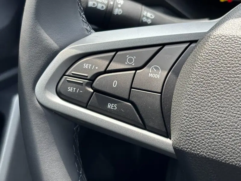 Gros plan sur les commandes de régulateur de vitesse noires intégrées au volant du Dacia Bigster blanc 2025.