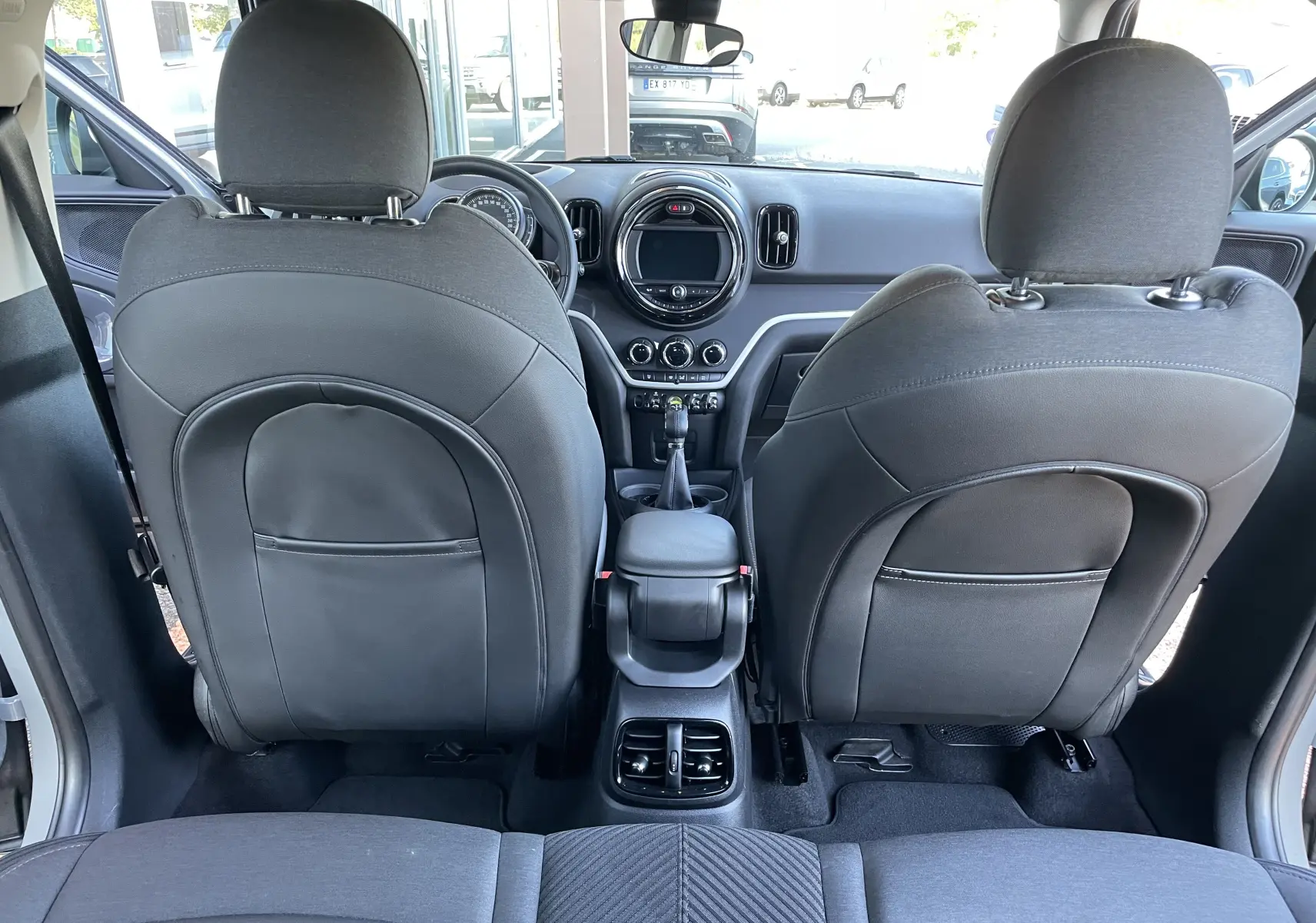 Vue arrière de l'intérieur gris noir d'une MINI COUNTRYMAN F60 136 ALL4 COOPER SE de 2019, avec sièges avant et tableau de bord visibles.
