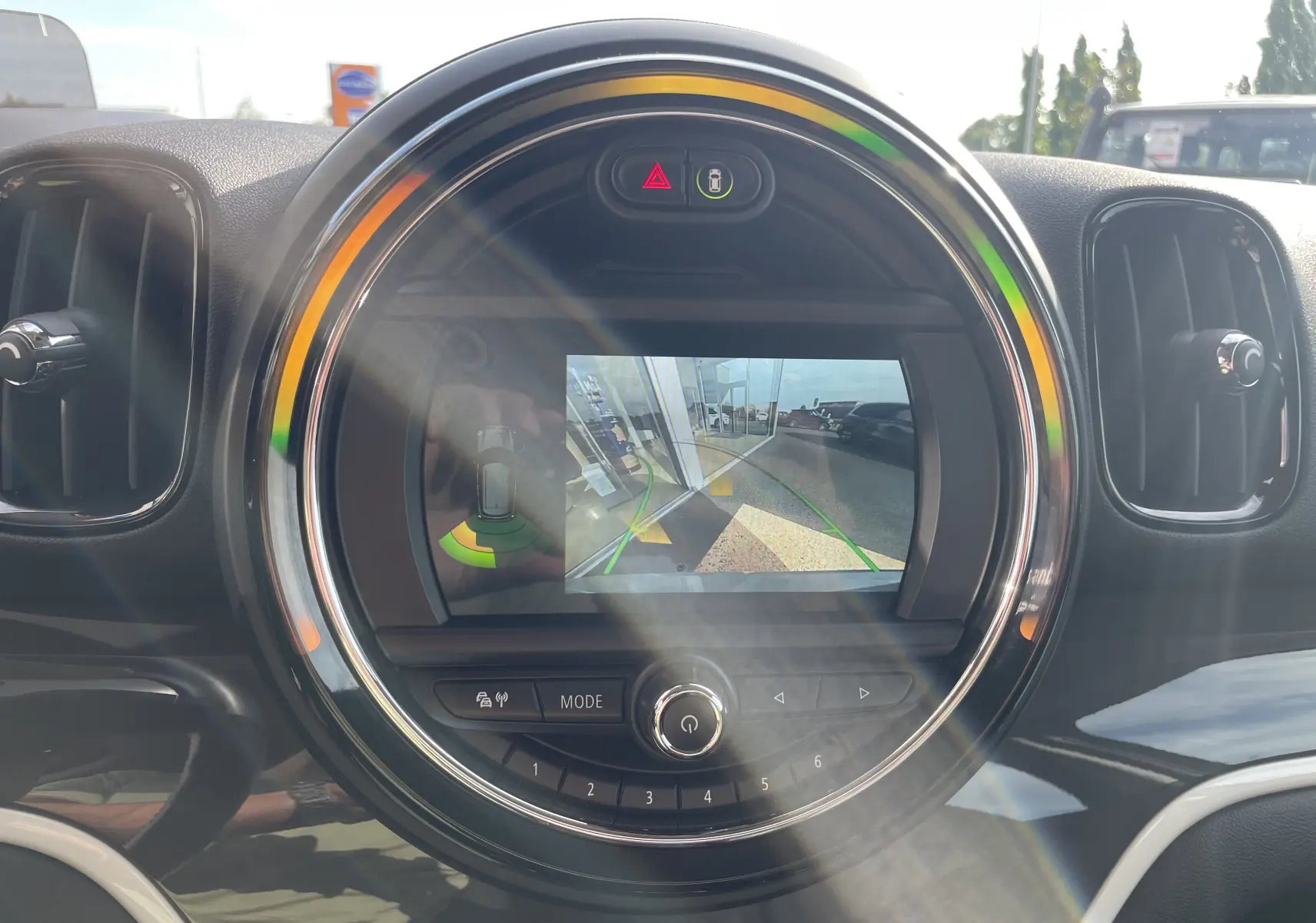 Écran central rond affichant la caméra de recul du MINI Countryman F60 hybride en intérieur noir et gris.