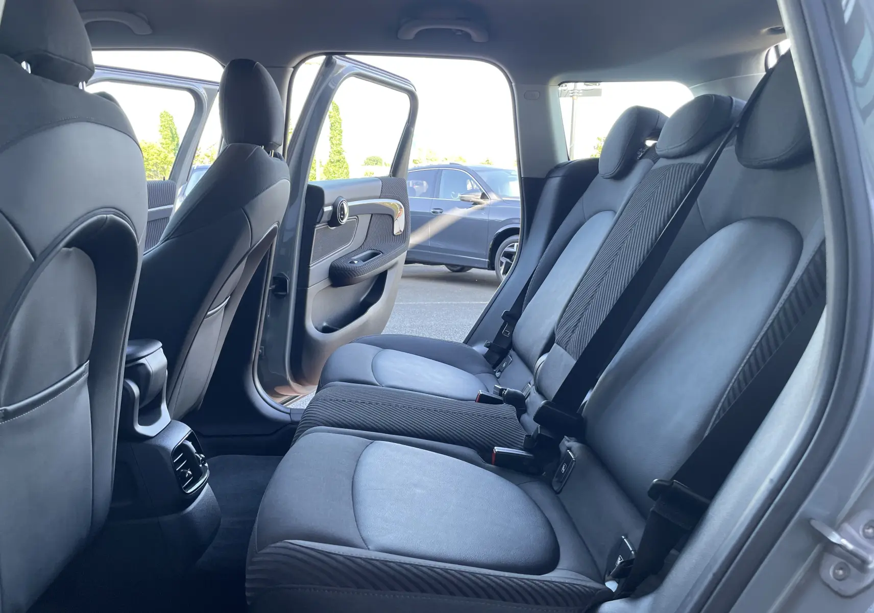 Vue intérieure côté droit sur les sièges arrière gris noir d'une MINI COUNTRYMAN F60 Moonwalk Grey avec porte ouverte.