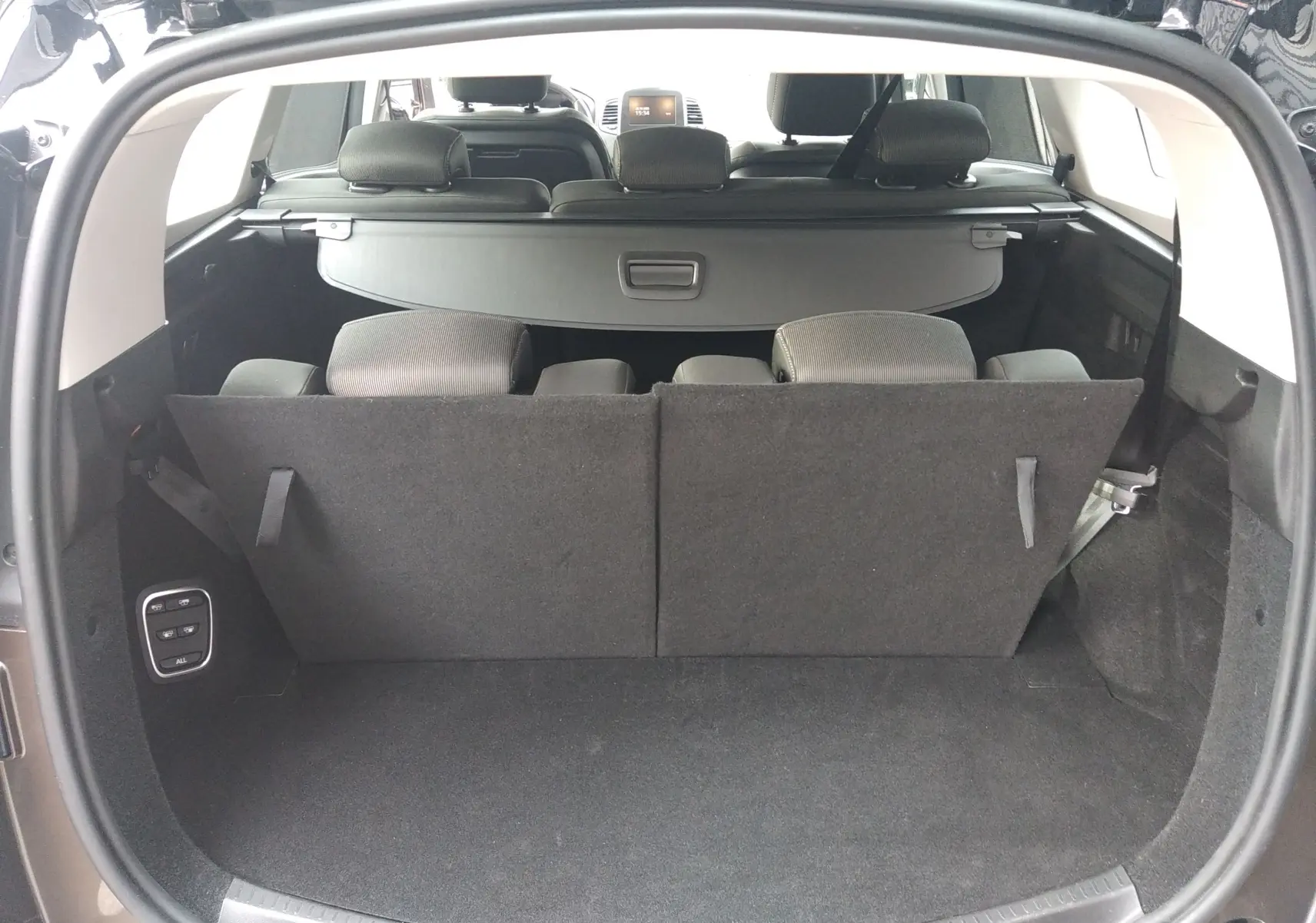 Coffre ouvert du Renault Grand Scenic brun vison, vue arrière montrant la banquette arrière et la tablette cache-bagages.