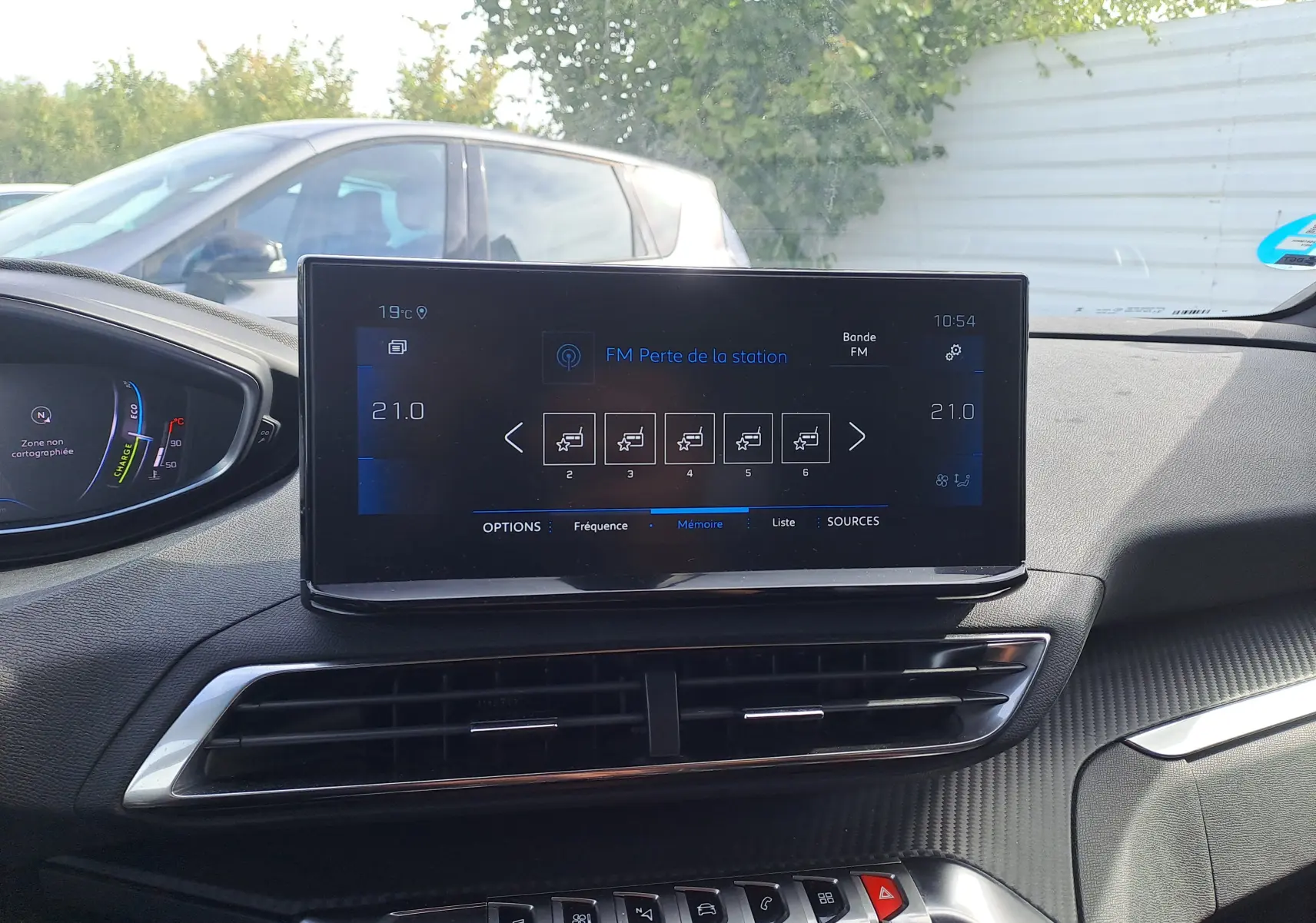 Écran tactile central du Peugeot 3008 Hybrid 145 Allure Pack 2024, affichant la radio FM, intérieur noir.