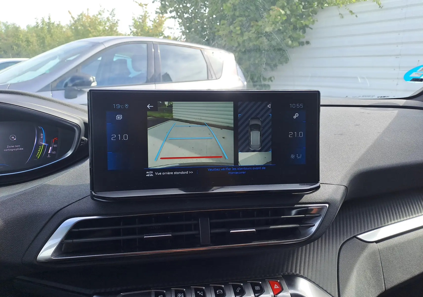 Vue intérieure du tableau de bord du Peugeot 3008 Hybrid 145 gris platinium avec écran multimédia affichant la caméra de recul.