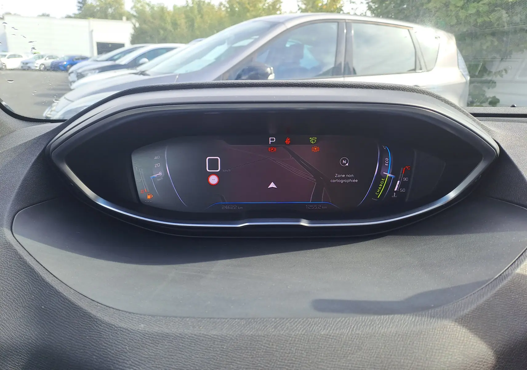 Tableau de bord numérique du Peugeot 3008 Hybrid 145 gris platinium affichant la vitesse à zéro et la navigation en pause.