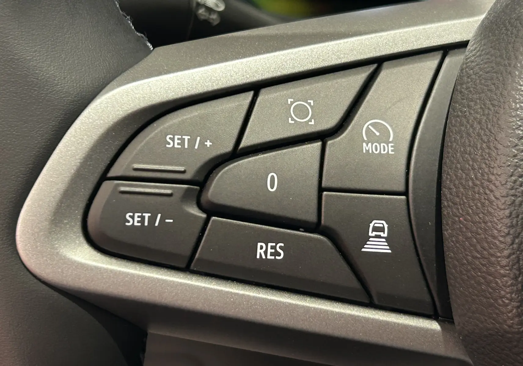 Gros plan sur les commandes de régulateur de vitesse au volant du Dacia Bigster 2026 finition Journey noir nacré.