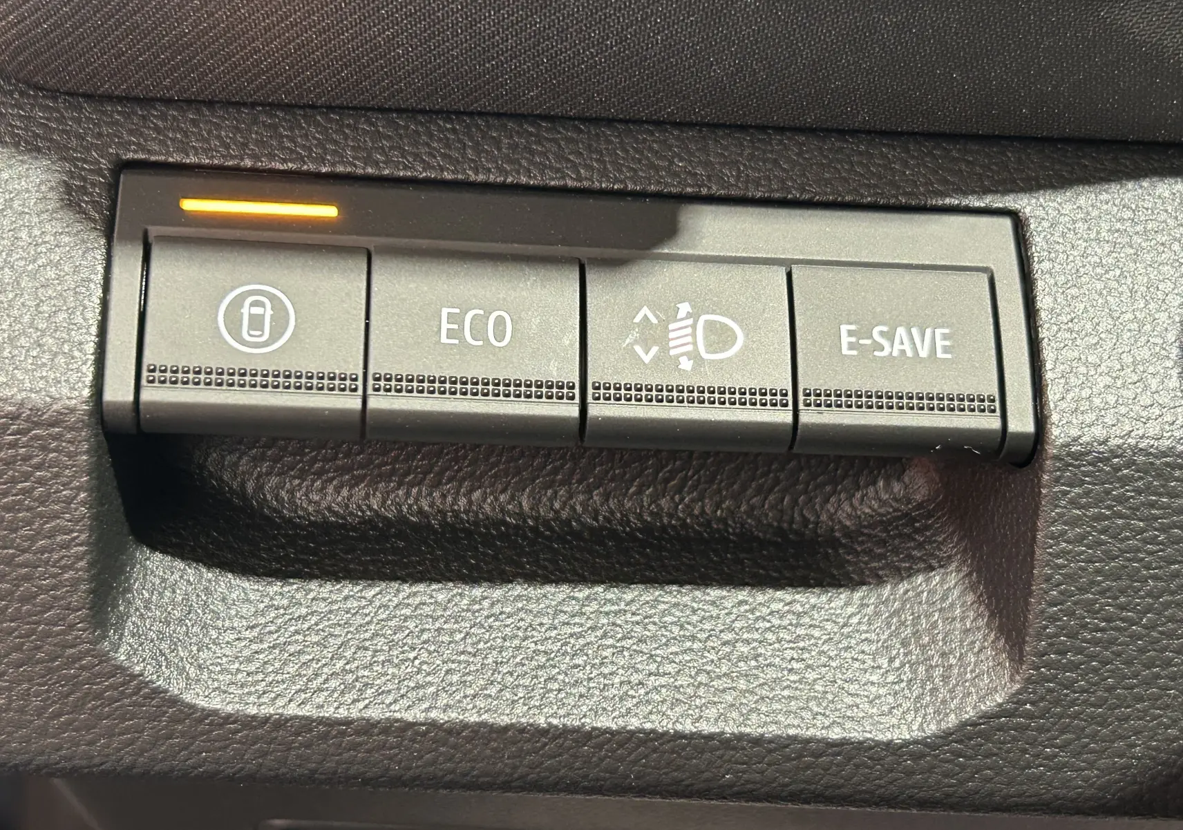 Boutons de commande du tableau de bord du Dacia Bigster 2026, avec fonction ECO et E-SAVE, éclairage orange actif.